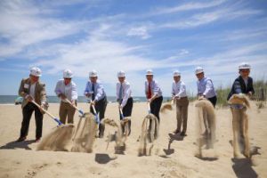 Men on beach shoveling sand