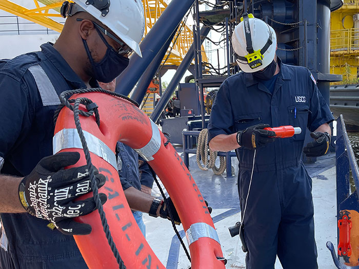 Coast Guard inspectors examine a life ring.