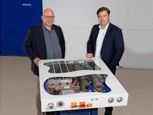Two men stand behind fuel cell