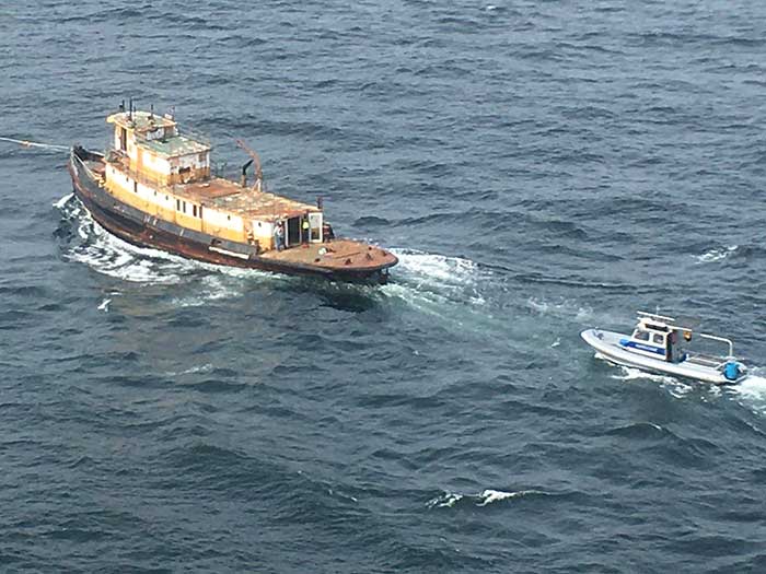 Derelict tugboat under tow prior to scuttling