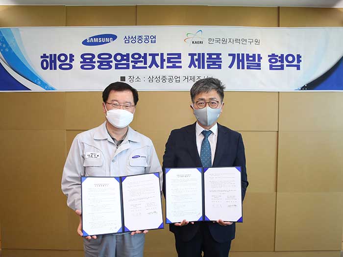 Two men in masks pose with documents