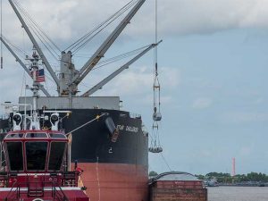 Ship transfers steel coil to barge