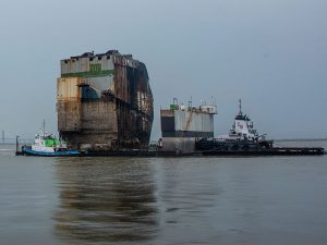 Sextion six of capsized car carrier Golden Ray is towed away