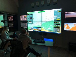 AMO deck officers Bridget Quinn and Adam Szloch remotely command the Nellie Bly in Denmark from Sea Machines' Boston control room. [Image: AMO]