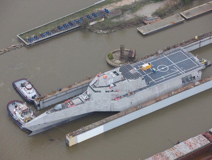 Austal USA shipyard with tugs and a military ship