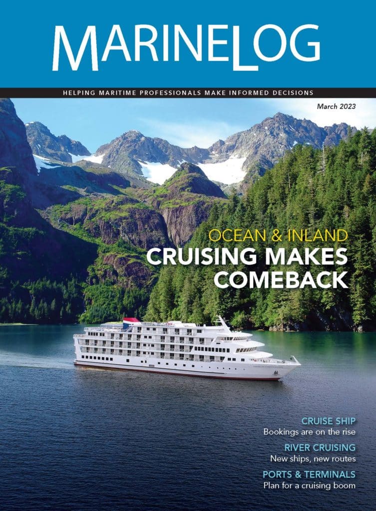 River cruise ship passes by mountains on the water