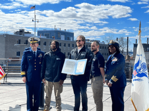 Rear Adm. John Mauger, the First Coast Guard District commander, and Capt. Zeita Merchant, the Coast Guard Sector New York commander and Captain of the Port of New York, present a Public Service Commendation to representatives from the NYC Ferry Vessel River Sprinter at Whitehall Ferry Terminal in New York City, March 9, 2023.