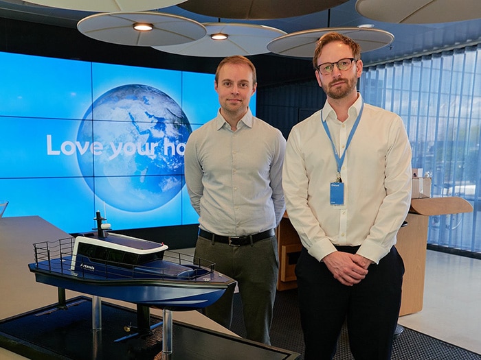 Two men with model of electric foiling CTV