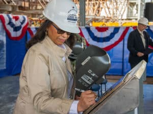 Ship’s sponsor and daughter of the namesake, signs her initials onto a steel plate that will be welded within DDG 131, the future USS George M. Neal.