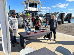 Marty Ozinga presents bibles to the captains of the three vessels.