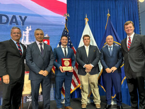 Stena Immaculate crew members, along with union and Crowley leadership, standing side by side with Gallant Ship Award plaque L to R: Willie Barrere, President, American Maritime Officers; Dimeter Mitev, chief engineer, Crowley; Peter Skerys, second mate, Crowley; Thor Pearson, chief mate, Crowley; Ion Sterie, bosun, Crowley; James C. Fowler, executive vice president & division president, Shipping & Logistics, Crowley. [Photo: Crowley]