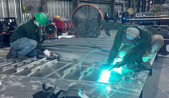 Workers at Bayou Metal Supply & Manufacturing’s facility in Slidell, Louisiana, fabricate structural components for HII’s Romulus unmanned surface vessel (USV) program. Bayou Metal, a strategic partner in the serial production of Romulus, recently launched a dedicated manufacturing line that provides precision cutting, bending, welding and assembly of major structural units for shipment to Breaux Brothers Enterprises, where final integration of the USV platform takes place. [Photo Credit: Bayou Metal Supply & Manufacturing]